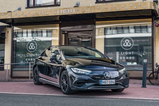 Musta Mercedes-Benz-henkilöauto hotellin edessä