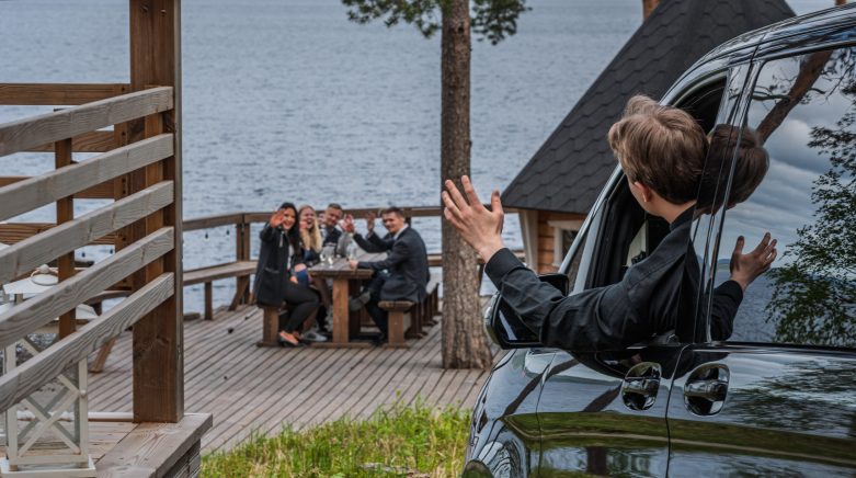 Kuljettaja vilkuttaa asiakkaille auton ikkunasta